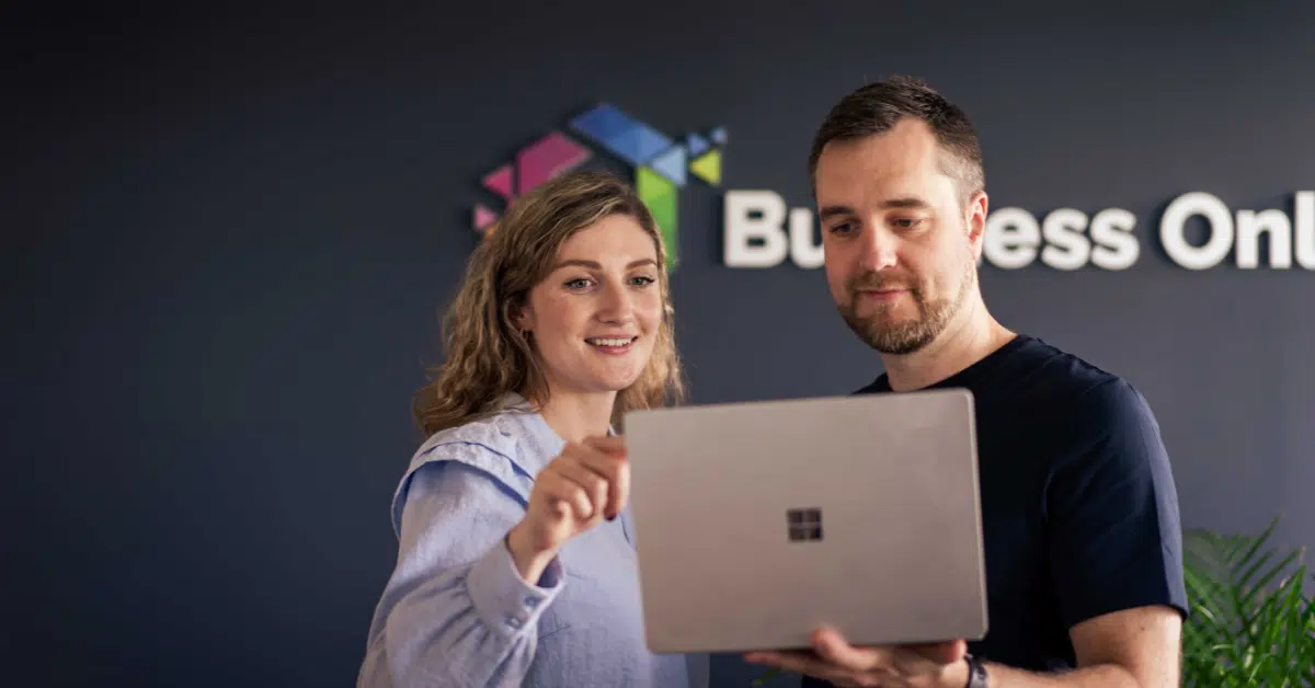 To kollegaer gjennomgår leverandørevaluering for Åpenhetsloven på laptop