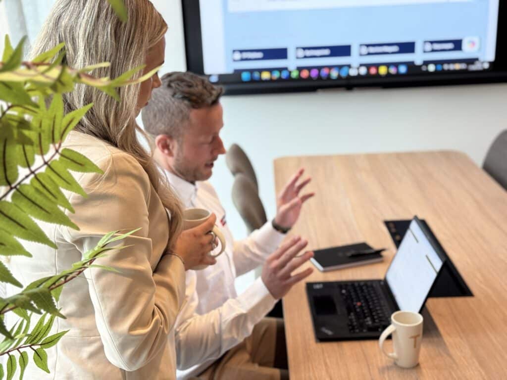 Two employees at Westing are discussing in front of a laptop: Alt text must first and foremost describe what the image actually shows (for screen readers and Google Images), with the focus keyword placed naturally. Do not cram «Business Online» or «CRM» in here if it is not visible in the image — it reads as keyword stuffing.
